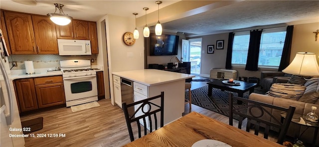 kitchen with decorative backsplash, a textured ceiling, white appliances, decorative light fixtures, and light hardwood / wood-style flooring