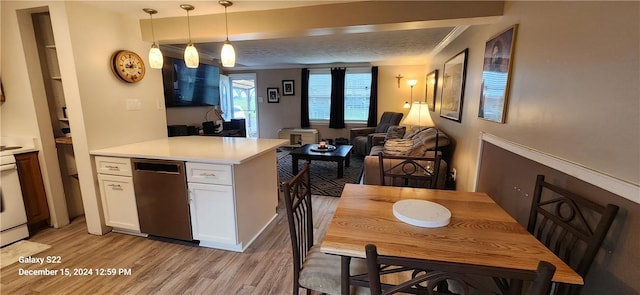 kitchen with pendant lighting, white cabinets, stainless steel dishwasher, a textured ceiling, and light hardwood / wood-style floors