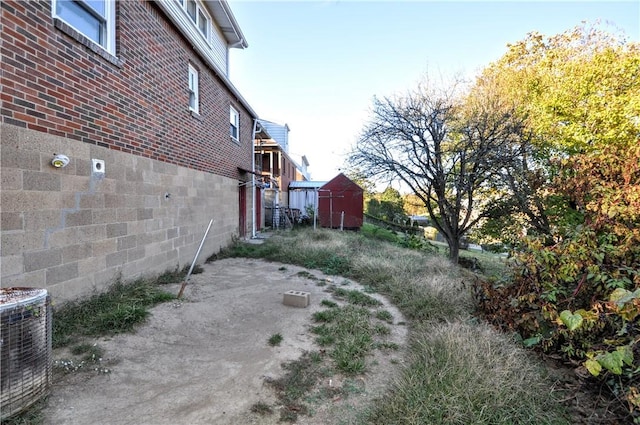 view of yard featuring central air condition unit and a storage unit