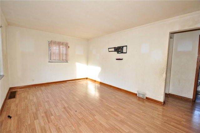 spare room with light hardwood / wood-style floors and ornamental molding