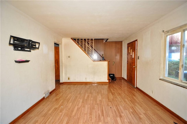 empty room with light hardwood / wood-style flooring and crown molding