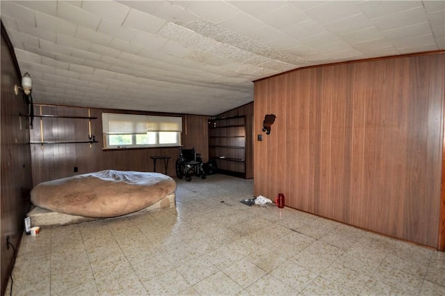 unfurnished bedroom featuring wooden walls and lofted ceiling