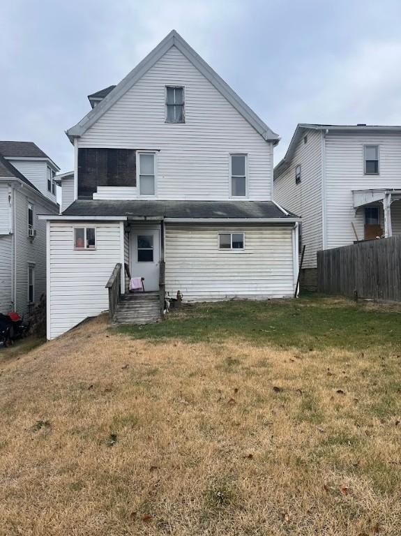 rear view of property featuring a yard