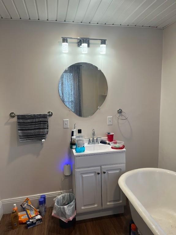 bathroom with a bathing tub, vanity, and hardwood / wood-style flooring