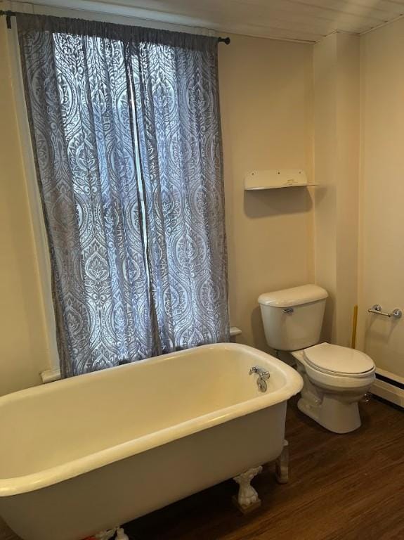 bathroom featuring hardwood / wood-style floors, a bath, and toilet