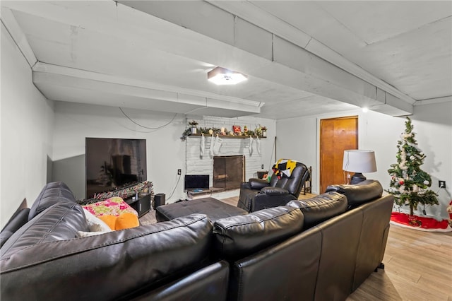 living room with a stone fireplace and wood-type flooring