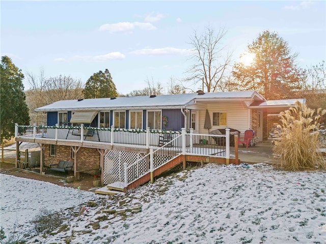 snow covered property featuring a deck and a patio area