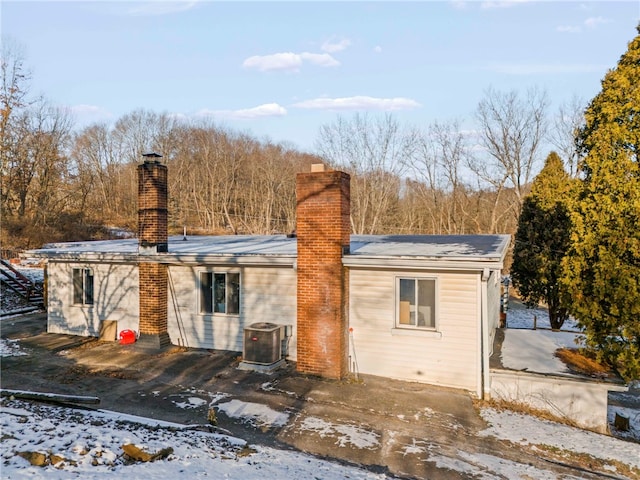 snow covered house with central AC unit