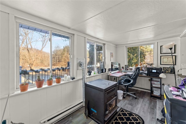 office space with baseboard heating, a textured ceiling, a healthy amount of sunlight, and dark hardwood / wood-style floors