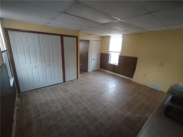 interior space with a paneled ceiling, two closets, and sink