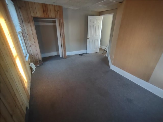 carpeted spare room with wooden walls