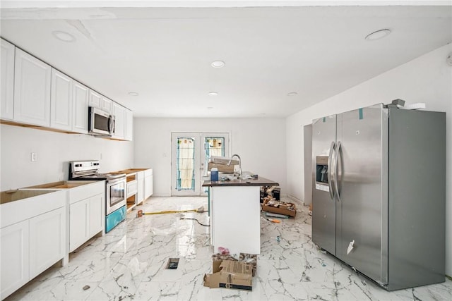 kitchen featuring a kitchen island with sink, french doors, white cabinets, and stainless steel appliances