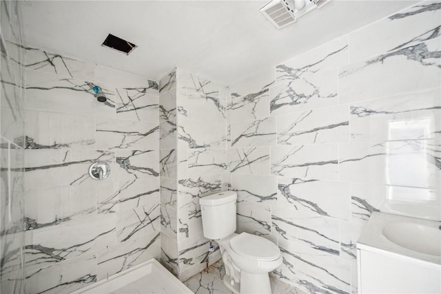 bathroom featuring toilet, vanity, and tiled shower