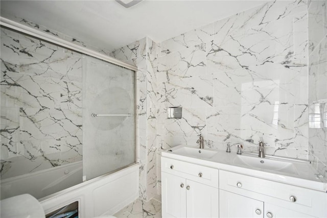 bathroom with shower / bath combination with glass door, vanity, and tile walls