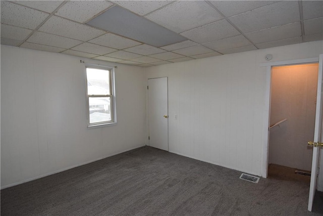 carpeted spare room with a drop ceiling