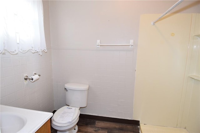 bathroom featuring hardwood / wood-style floors, vanity, tile walls, and toilet