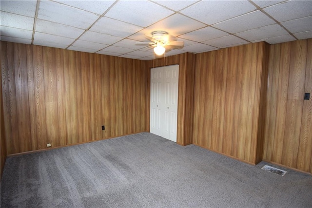 unfurnished room with a drop ceiling, ceiling fan, and carpet floors