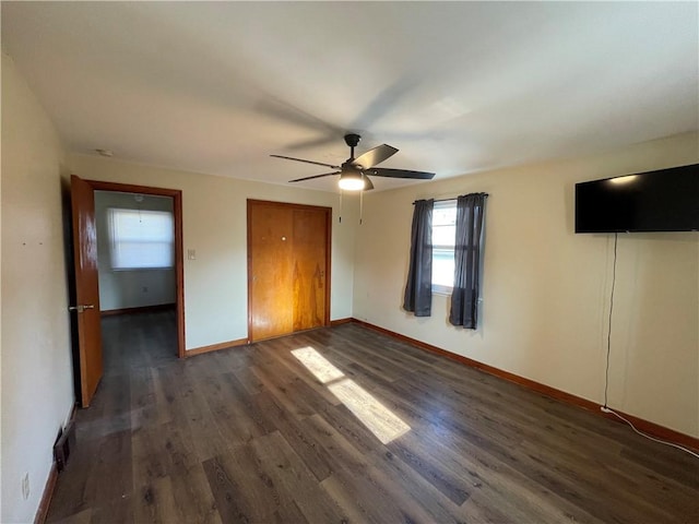 unfurnished bedroom featuring ceiling fan and dark wood-type flooring