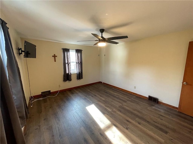 empty room featuring dark hardwood / wood-style flooring and ceiling fan