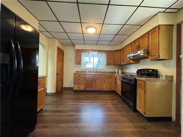 kitchen with dark hardwood / wood-style flooring, a paneled ceiling, sink, and black appliances