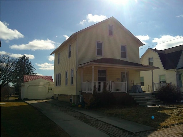 country-style home with a porch, an outbuilding, and a detached garage