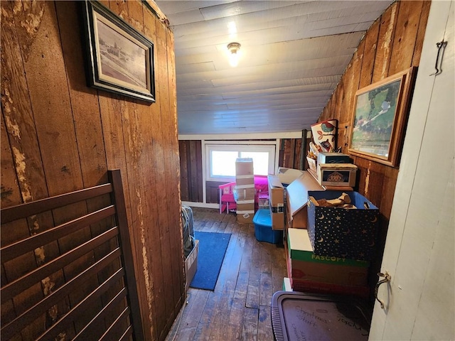 interior space featuring dark hardwood / wood-style flooring, vaulted ceiling, and wood walls