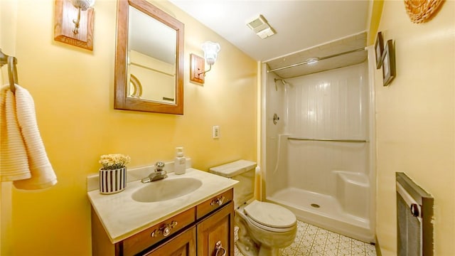 bathroom featuring vanity, toilet, and a shower