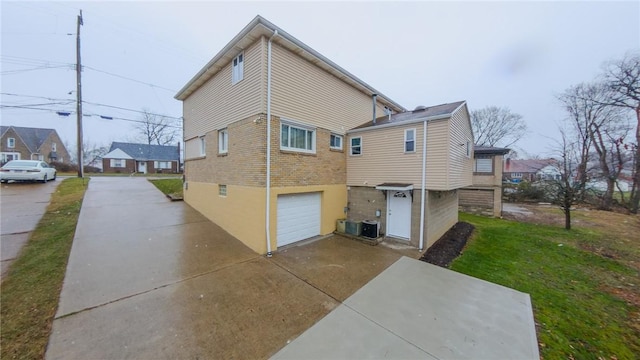 back of house featuring a garage and central air condition unit