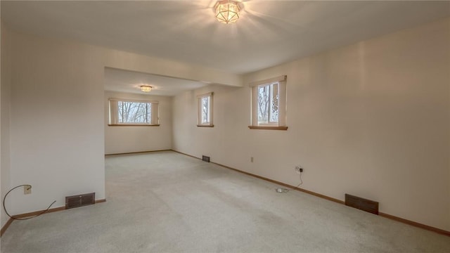 empty room with light colored carpet and plenty of natural light