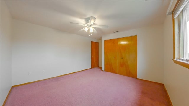 unfurnished bedroom featuring carpet, ceiling fan, and a closet