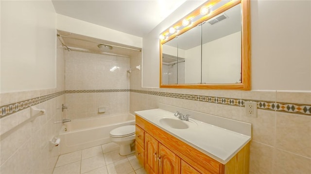 full bathroom featuring tile patterned flooring, vanity, toilet, and tile walls