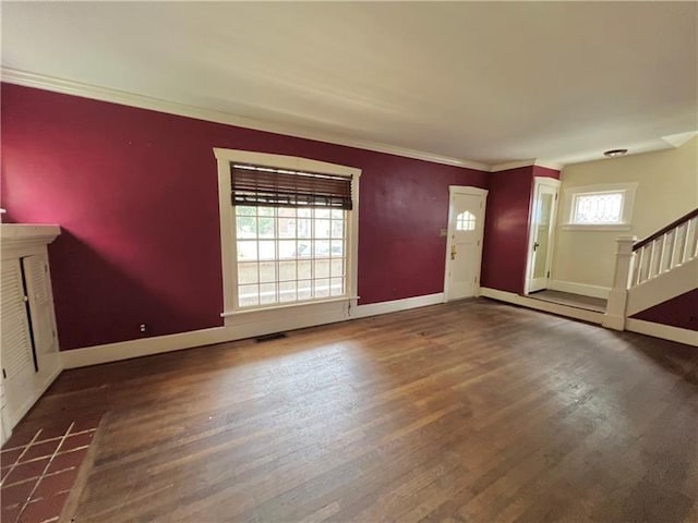 foyer with a healthy amount of sunlight, dark hardwood / wood-style floors, and ornamental molding