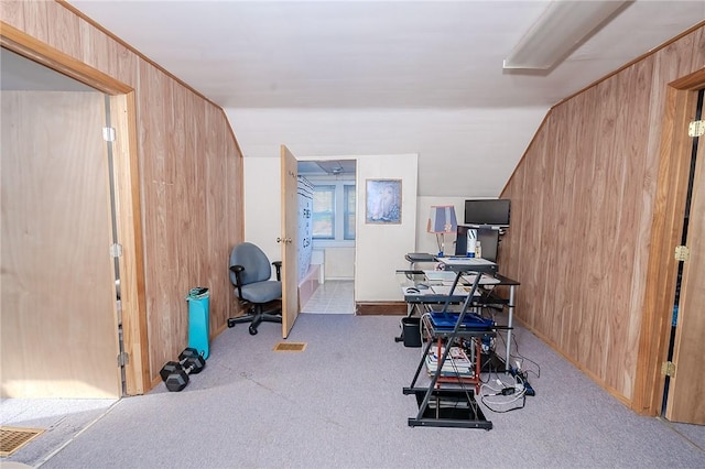 carpeted office space featuring lofted ceiling and wooden walls