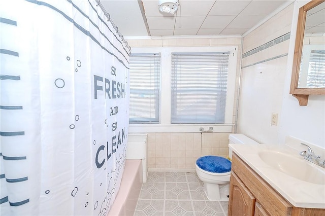 full bathroom with vanity, tile patterned floors, toilet, shower / bathtub combination with curtain, and tile walls