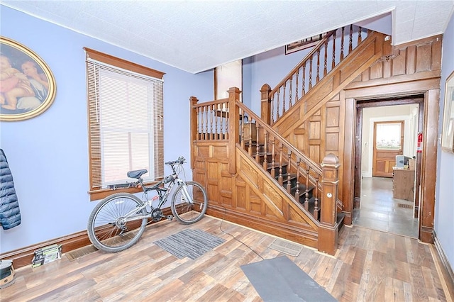 staircase with hardwood / wood-style floors and wood walls