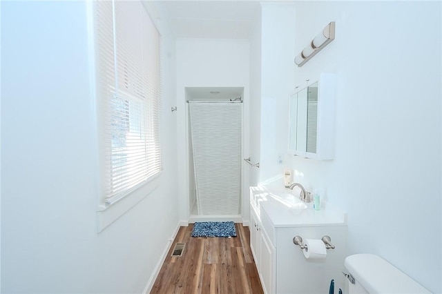 bathroom featuring hardwood / wood-style flooring, vanity, curtained shower, and toilet