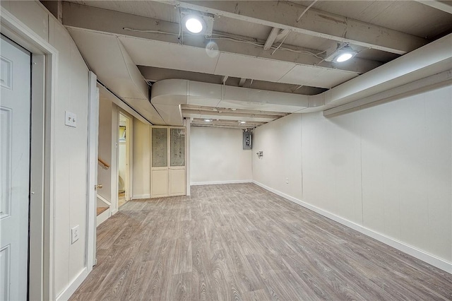 basement with hardwood / wood-style floors and electric panel