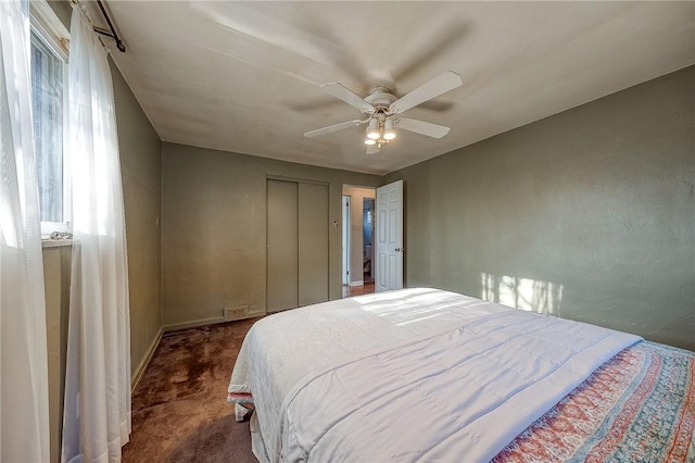 bedroom with dark colored carpet, a closet, and ceiling fan