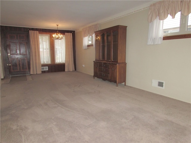 interior space with carpet flooring, plenty of natural light, and a chandelier