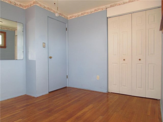 unfurnished bedroom with hardwood / wood-style floors and a closet