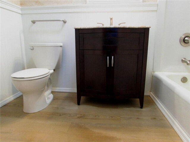 bathroom with toilet, vanity, and hardwood / wood-style flooring