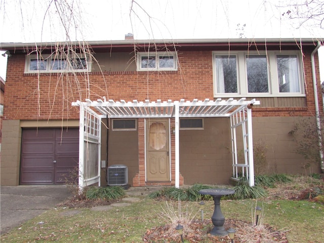 back of property with central AC and a garage