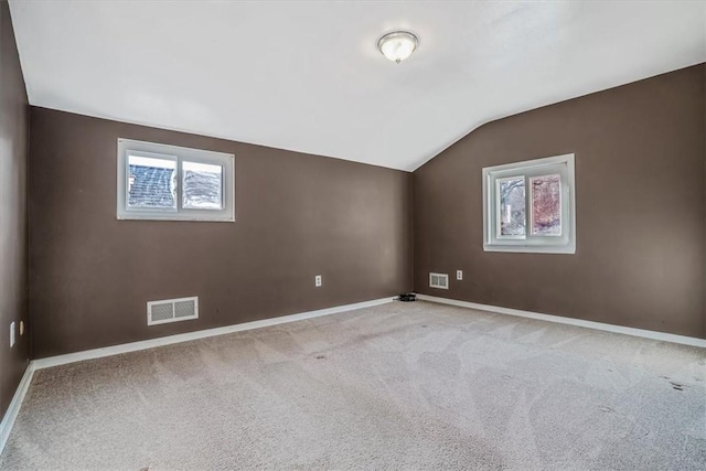 bonus room with light carpet and vaulted ceiling