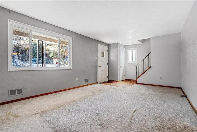 interior space featuring light colored carpet and a wealth of natural light