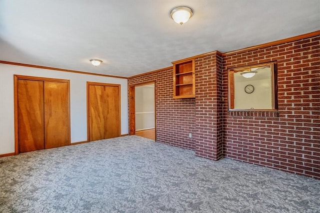 interior space with carpet flooring, brick wall, and ornamental molding