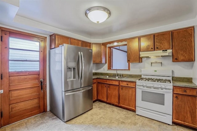 kitchen featuring sink, stainless steel refrigerator with ice dispenser, and white range with gas cooktop