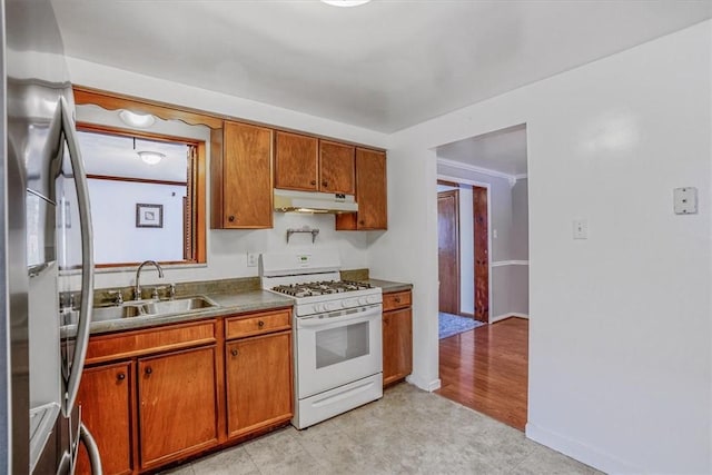 kitchen with stainless steel fridge, light hardwood / wood-style flooring, white gas range, and sink