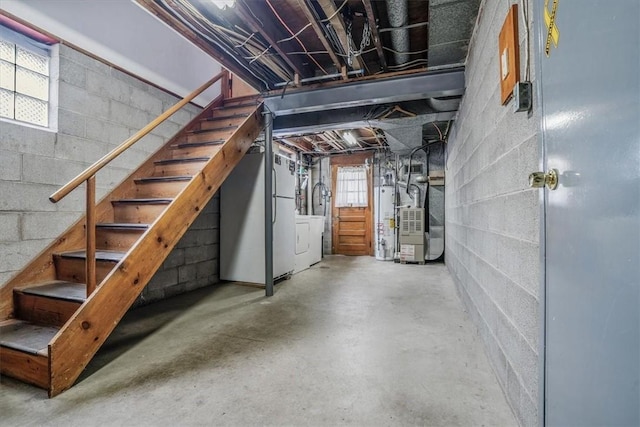 basement featuring plenty of natural light, stainless steel fridge, gas water heater, and heating unit