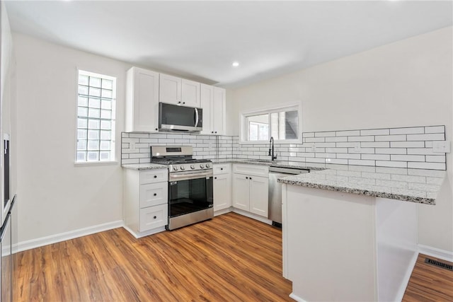 kitchen featuring white cabinetry, a wealth of natural light, and stainless steel appliances