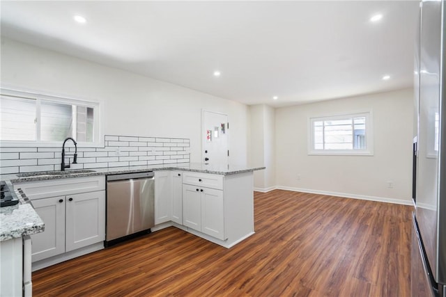 kitchen with white cabinets, appliances with stainless steel finishes, decorative backsplash, and dark hardwood / wood-style floors